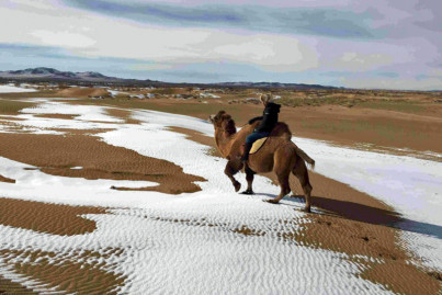 Riding a camel across Mongolian desert